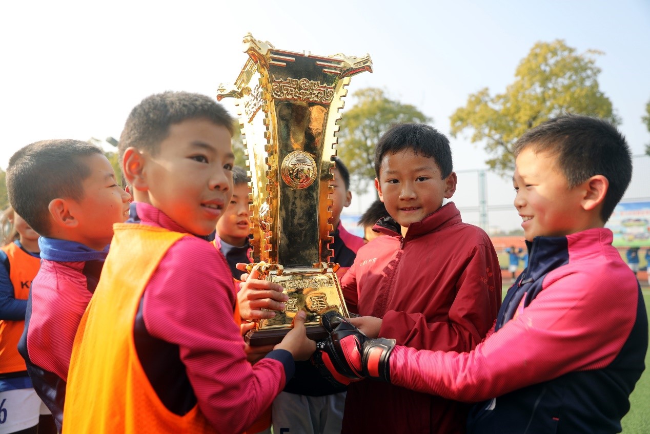 孩子们捧起足协杯冠军奖杯。